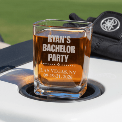 Personalized glass with 'Ryan's Bachelor Party' text on a car cup holder with a blurred background