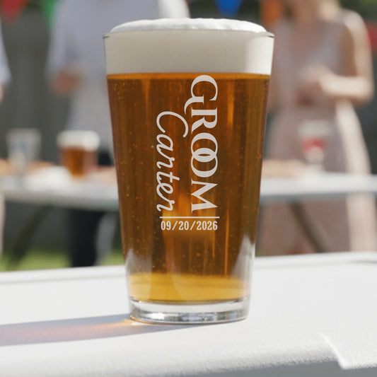 Pint glass with 'Groom Carter 09/20/2026' text on a blurred outdoor background