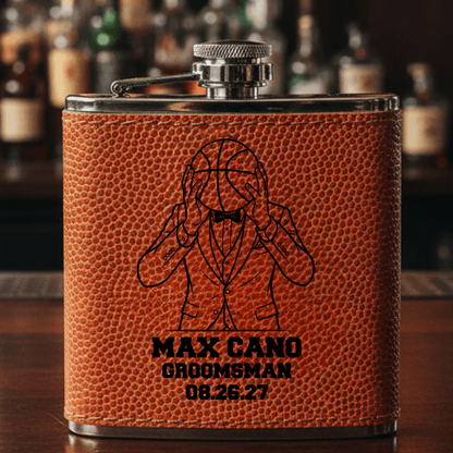 Brown leather basketball groomsmen flask with engraved design and text on a bar counter
