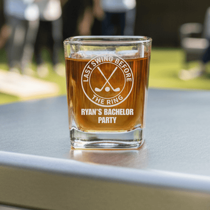 Glass of beer with 'Last Swing Before the Ring' and 'Ryan's Bachelor Party' text on a table outdoors.