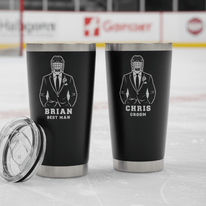 Two black tumblers with engraved designs and names on a hockey rink background