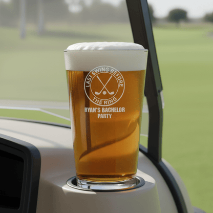 Pint glass with a printed design on a car cup holder with a golf course background