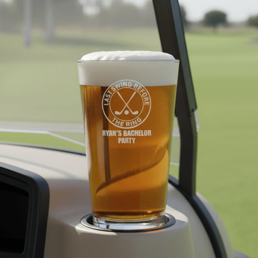 Pint glass with a printed design on a car cup holder with a golf course background