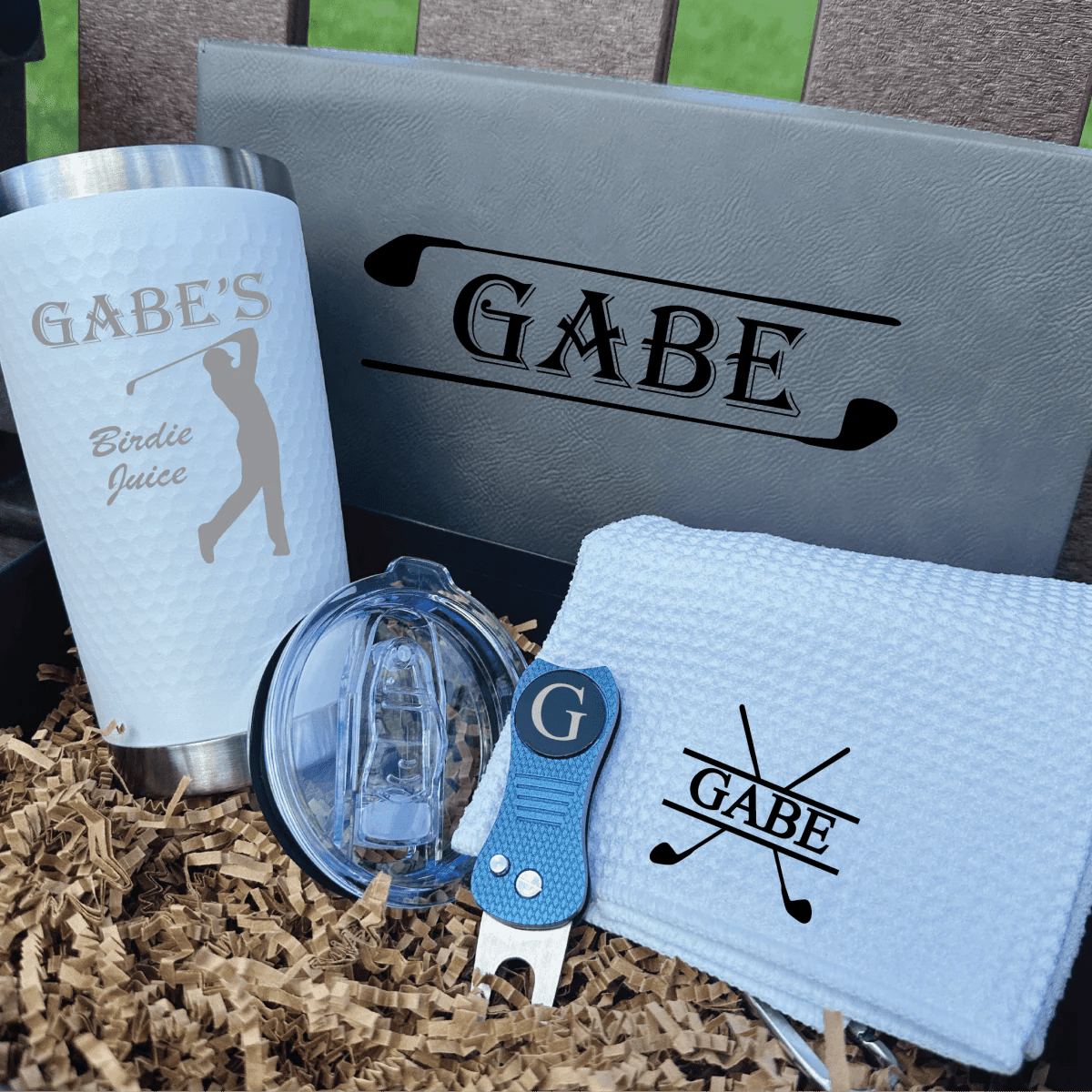 Golf-themed gift set with 'Gabe' branding on a textured surface.
