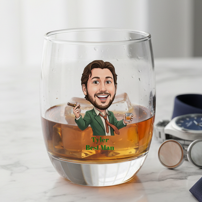 Personalized glass with a caricature of a man holding a cigar and glass, labeled 'Tyler Best Man', on a marble surface.