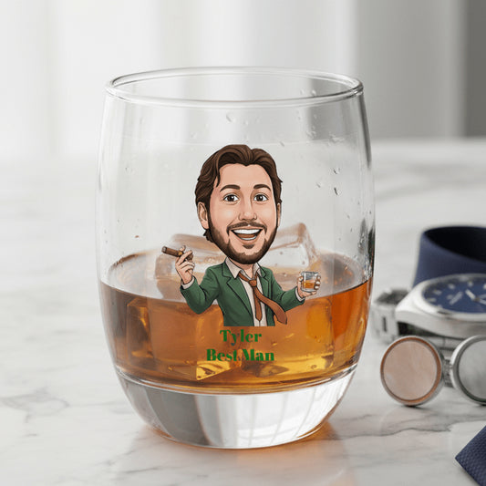 Personalized glass with a caricature of a man holding a cigar and glass, labeled 'Tyler Best Man', on a marble surface.