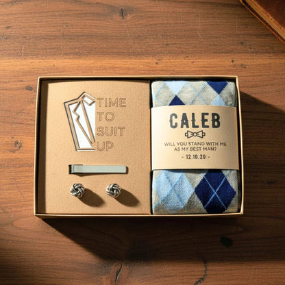 Groomsmen gift set with tie clip, cufflinks, and socks in a box on a wooden surface
