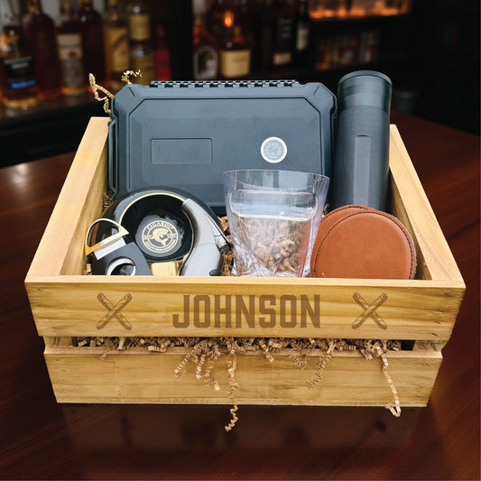 Personalized groomsmen cigar gift set in an engraved wooden crate with a cigar humidor and whiskey glass.