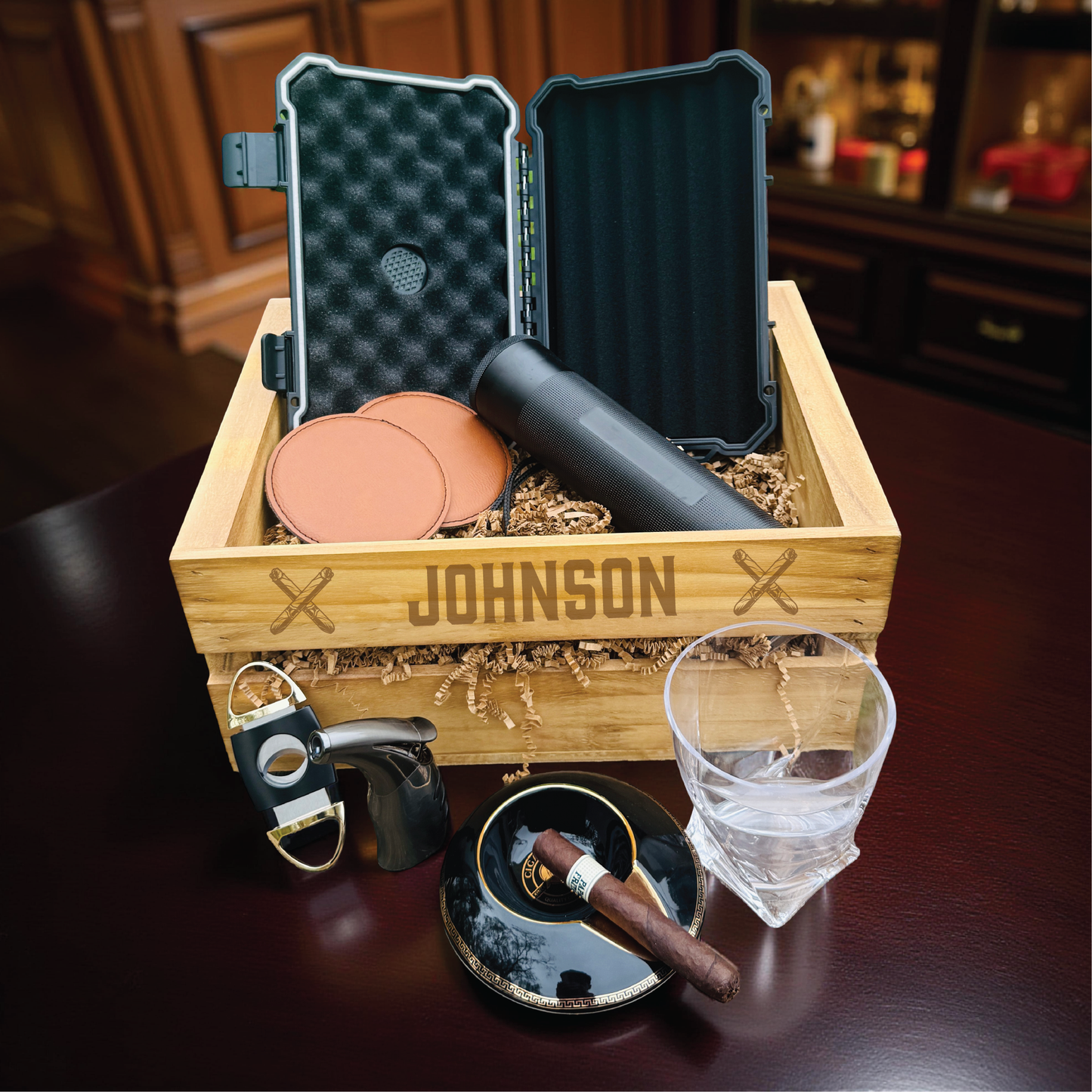 Personalized groomsmen cigar gift set in an engraved wooden crate with a cigar humidor and whiskey glass.