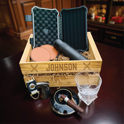 Personalized groomsmen cigar gift set in an engraved wooden crate with a cigar humidor and whiskey glass.