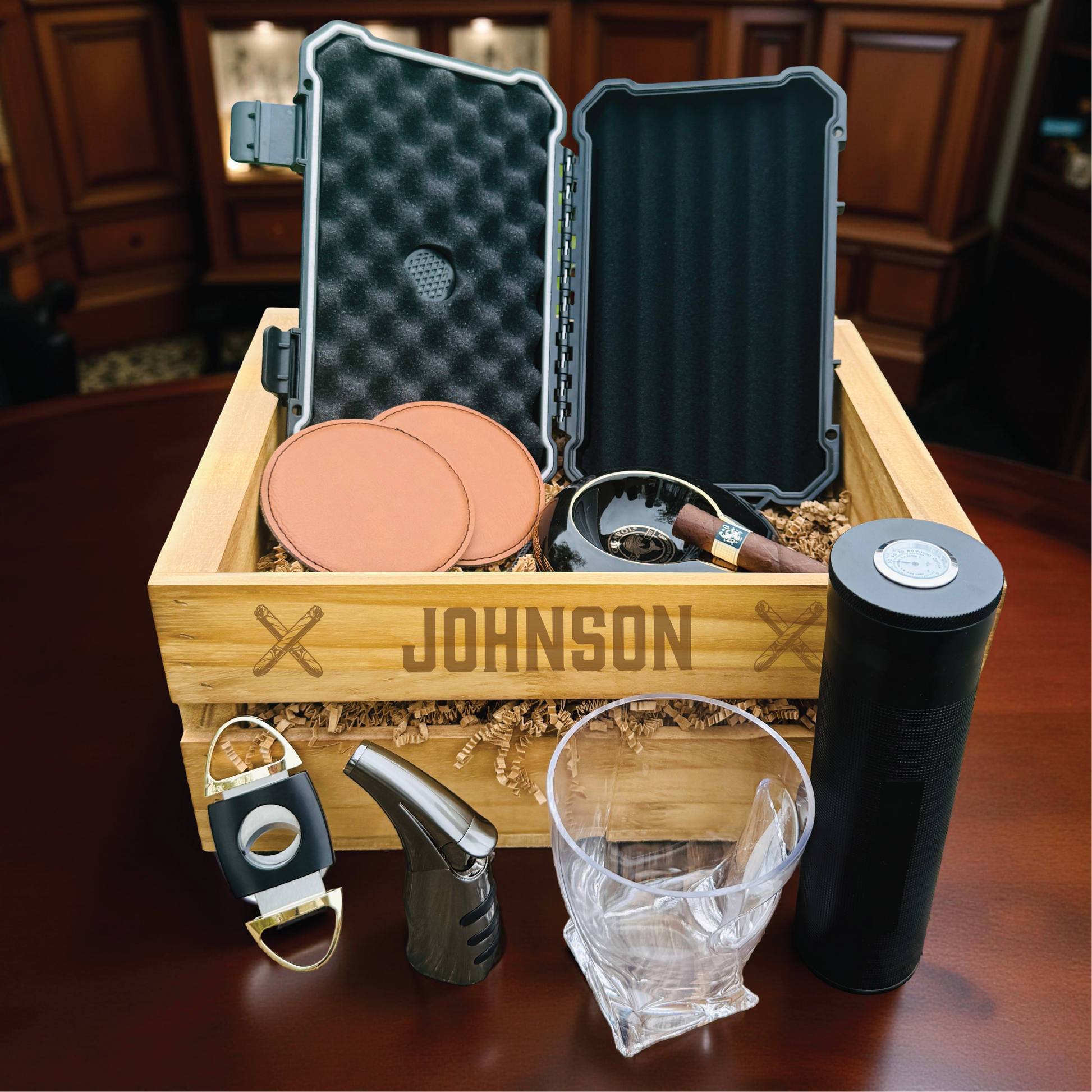Personalized groomsmen cigar gift set in an engraved wooden crate with a cigar humidor and whiskey glass.