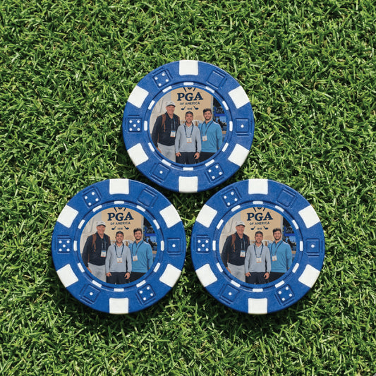 Three blue poker chips with PGA of America branding on a grass background