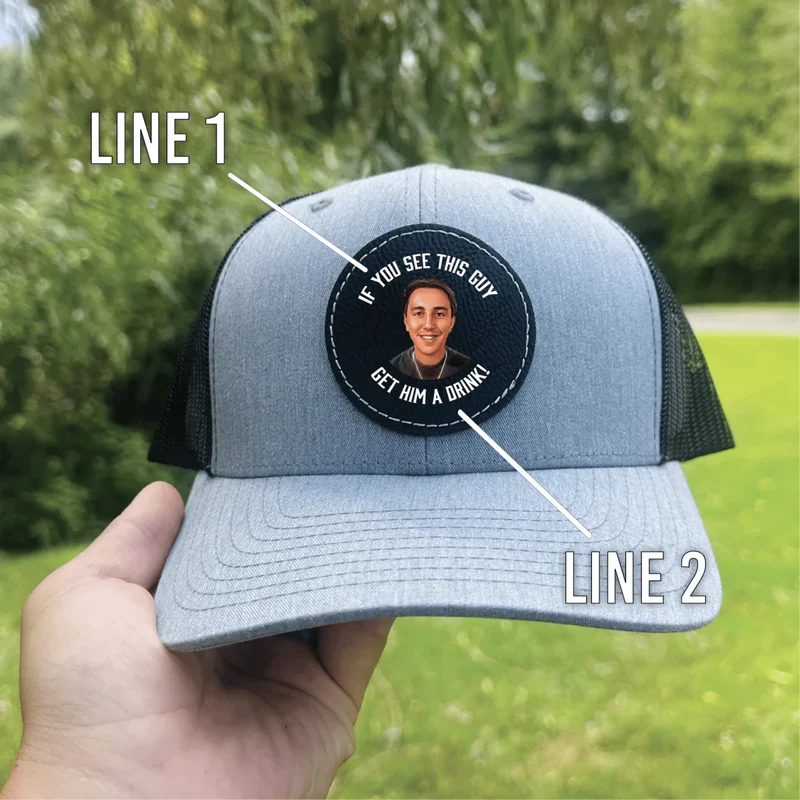 Gray and black trucker hat with circular patch showing sample personalization of photo and custom text on front and brim.