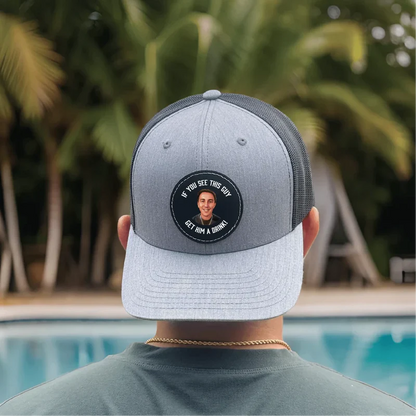 Two-tone mesh baseball cap with custom circular photo patch on front showing personalized image and text sample, worn outdoors by pool.
