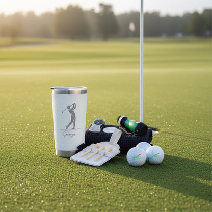 White insulated tumbler with sample personalization "George" and golfer silhouette, displayed on putting green with golf balls, tees, rangefinder, and black golf towel.