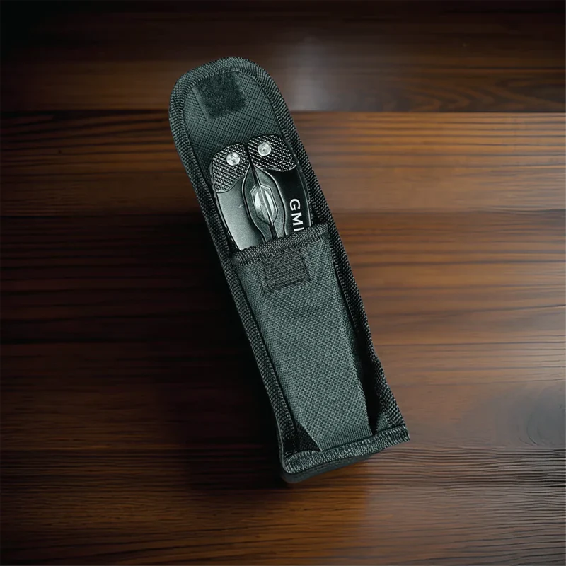 Gray fabric case containing a personalized multi-tool with sample initials "GM" engraved on the blade, displayed on wooden surface