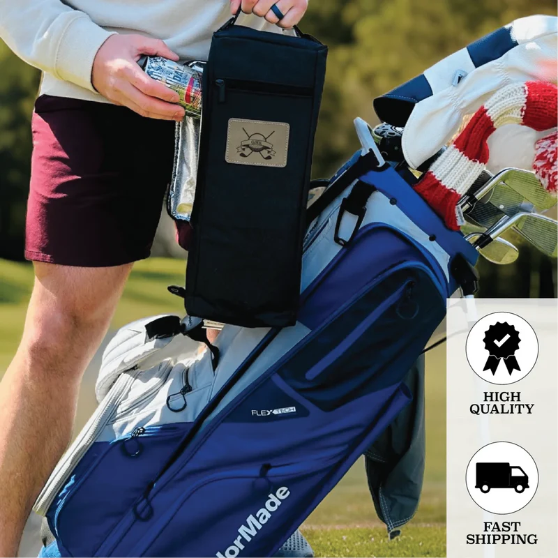 Person holding black insulated golf bag cooler with engraved anchor emblem, displayed next to blue golf bag on grass course.
