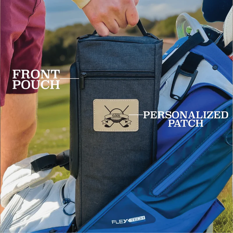Dark blue golf bag cooler with front zipper pouch and sample personalized leather patch showing golf club initials, held outdoors on golf course