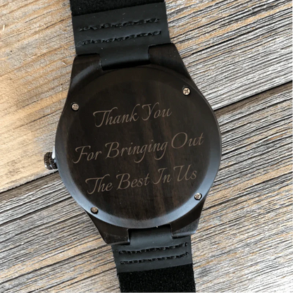 Black wood watch with leather strap, engraved sample text reading "Thank You For Bringing Out The Best In Tls" on the face.